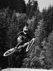 Mountain biker in mid-air going over a jump.