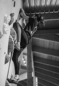 Woman climber scaling indoor climbing wall.